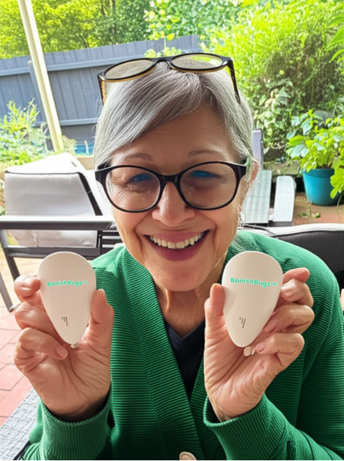 Grandmother showing BanishBugs devices on patio